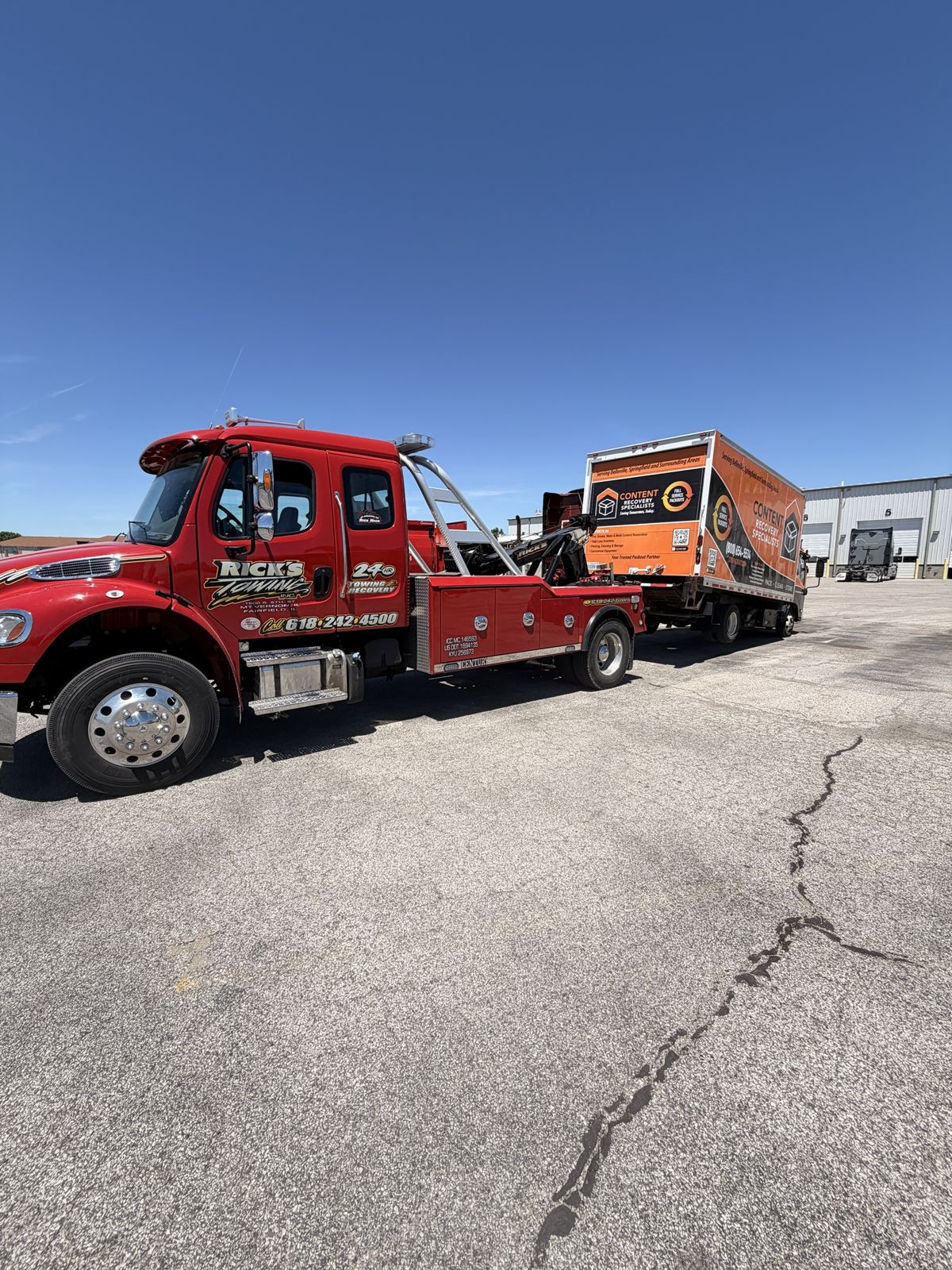 Rick's Towing wrecker towing a commercial box truck